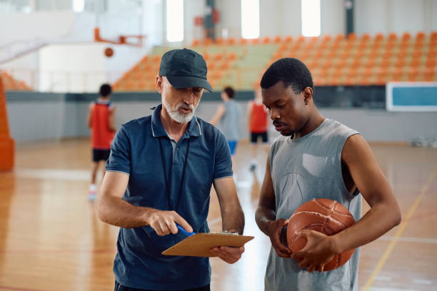 istock Basketball coach explaining game plan to black player during sports training. 2151849697