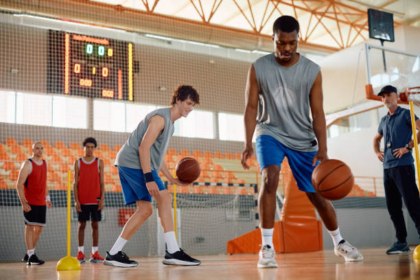 istock Happy player practicing during basketball training in school gymnasium. 2151849716
