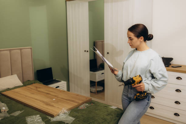 istock Women holding electric screwdriver and reading installation manual document to assembling furniture. 2151853655