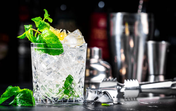 istock Summer refreshing drink cocktail with mint, lemon, vodka and gin tonic. Bar tools. Dark background bar counter 2151853880