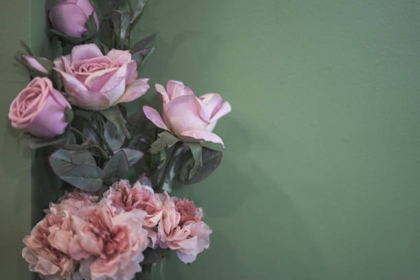 Pink plastic flowers on the wall background
