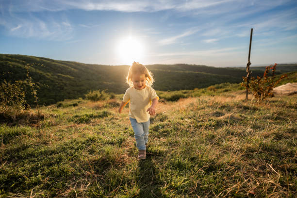 Full length of a cute little girl walking on the hill