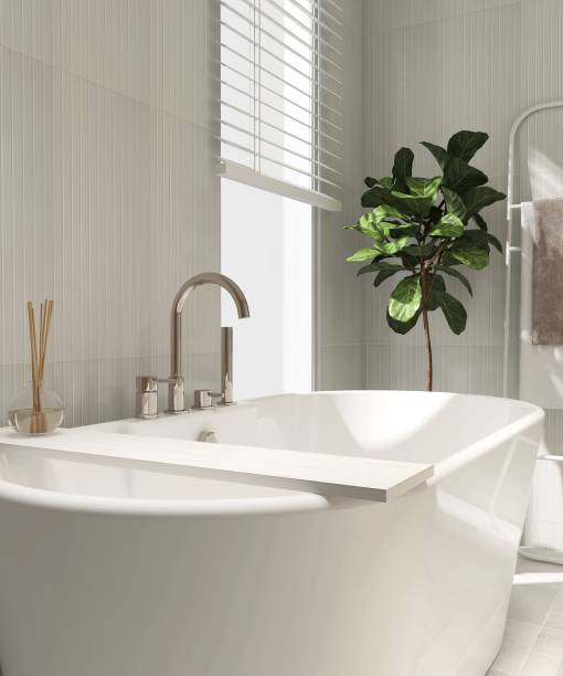 istock White wood plank caddy tray, reed stick diffuser, freestanding bathtub, chrome shower head in sunlight on cream tile bathroom 2151859069