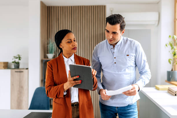 istock Colleagues discussing work while walking together at the office 2151860026