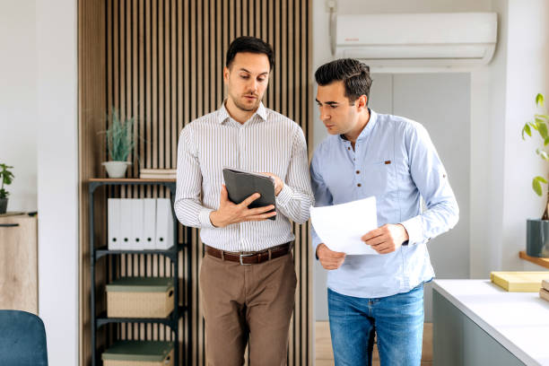 istock Two male colleagues walking and discussing work at the office 2151860084