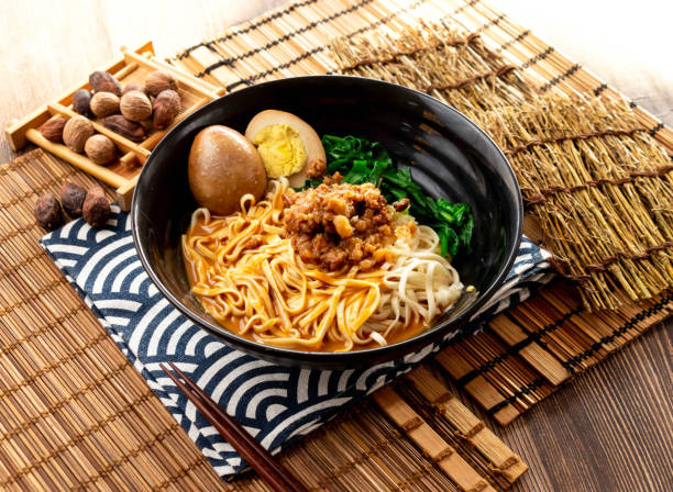 istock sesame paste noodles with minced pork meat, preserved egg and chopsticks served in plate isolated on napkin side view on table taiwan food 2151860704