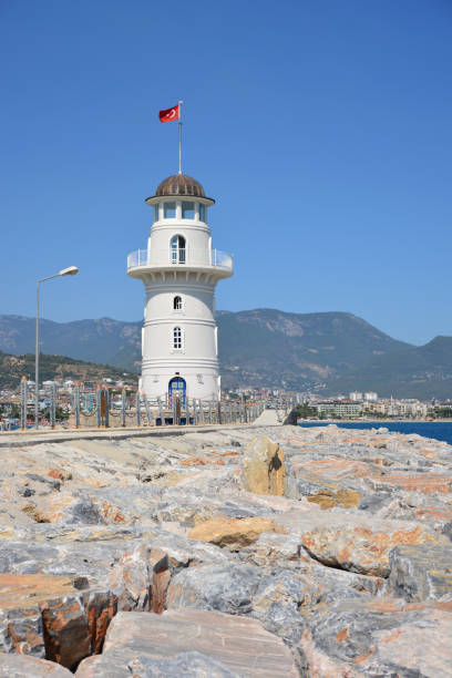 istock a white lighthouse with a flag on the top of it 2151862362