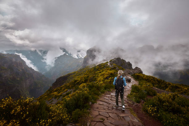 istock Rear view of a female backpacker walking on a mountain. 2151864152