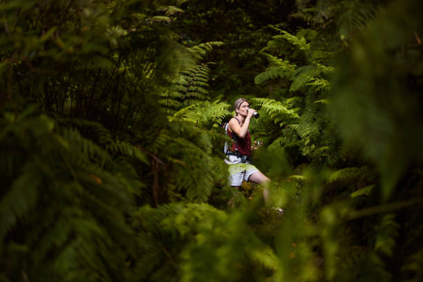 Carefree female hiker having water break among greenery in nature.