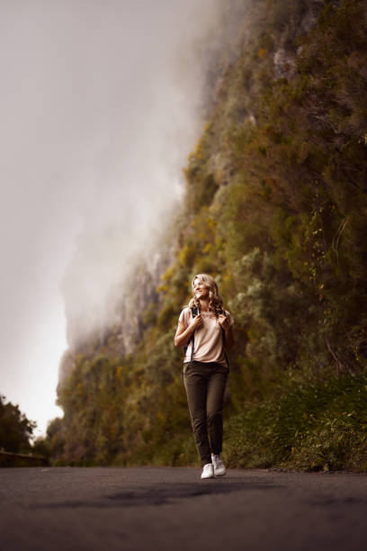 istock Happy woman walking on empty road in nature. 2151864318