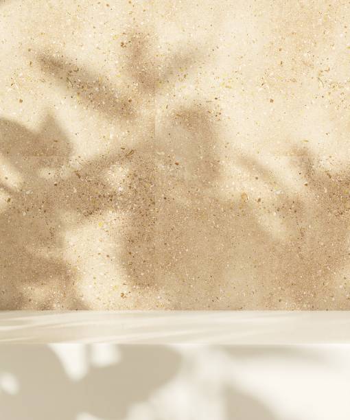 Minimal empty white stone countertop in sunlight, tropical leaf foliage shadow on yellow brown terrazzo wall