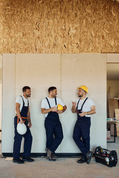 istock Group of happy manual workers talking at construction site. 2151866970