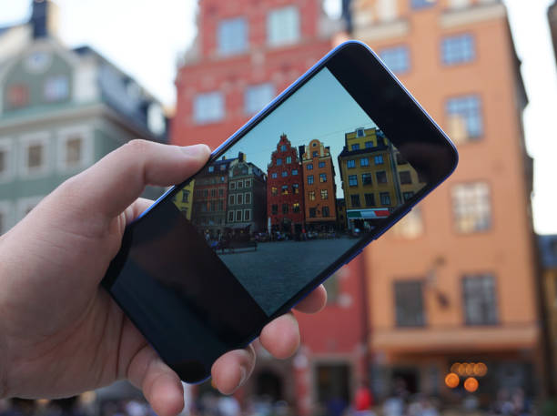 istock Cropped hand holding a mobile phone against buildings 2151867535