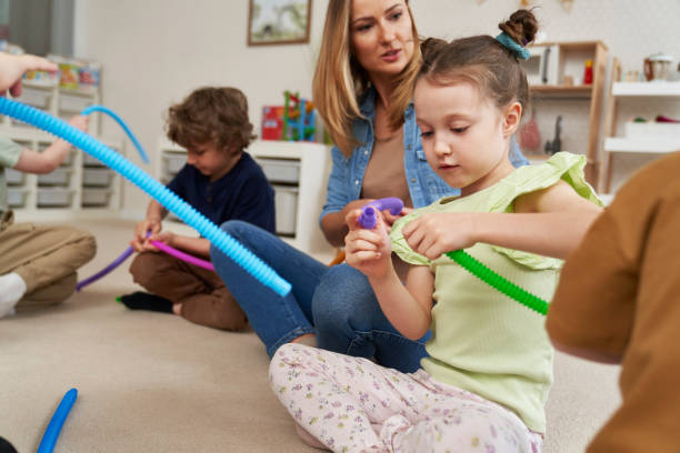 istock Teacher and children doing sensory exercises with pipes 2151872139