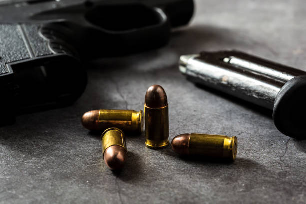 istock 9 mm gun with bullets on the table 2151872254