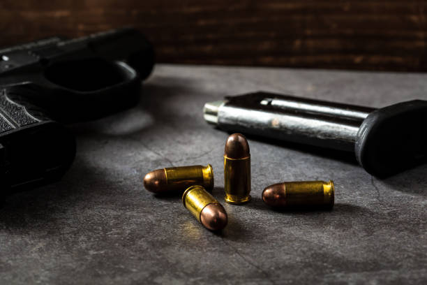 istock 9 mm gun with bullets on the table 2151872263