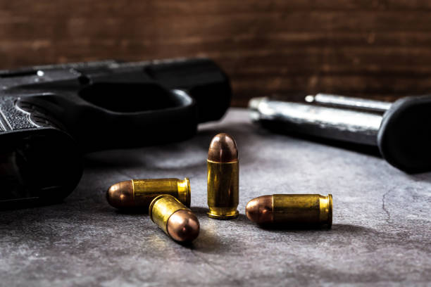 istock 9 mm gun with bullets on the table 2151872267