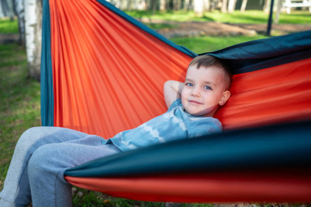 istock Cute joyful boy playing in the hammock outdoors 2151872451