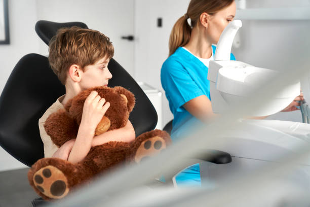 istock Child holding a teddy bear at the dentist's office 2151876263