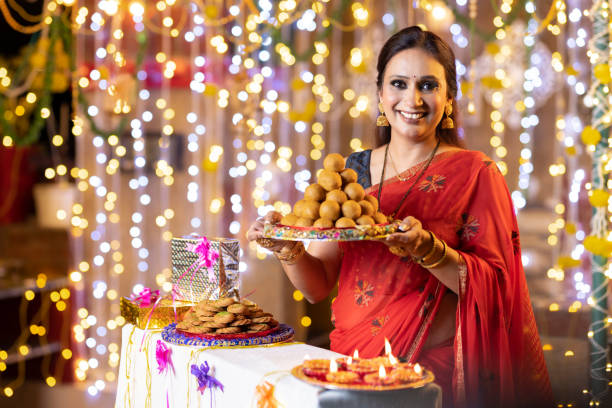 istock Young woman diwali celebrate with sweets 2151876733