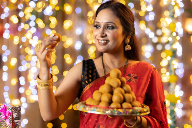 istock Young woman diwali celebrate with sweets 2151876756