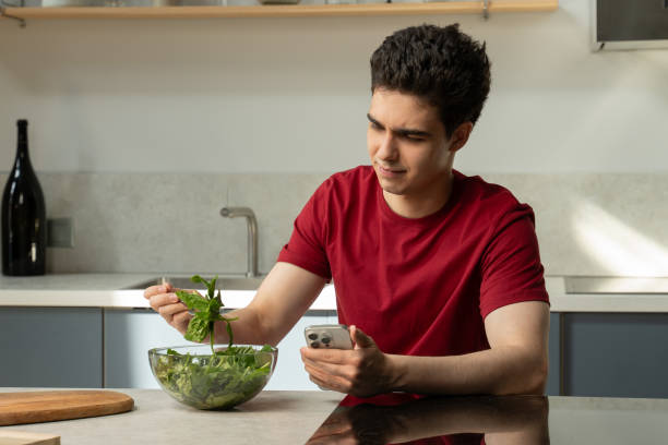 istock Young Man Experiences Disappointment With Bland Salad in Modern Kitchen During Lunchtime 2151878007