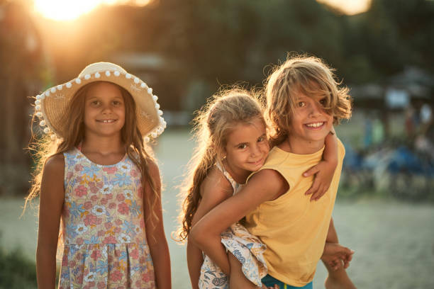 Beautiful children enjoying sunset on a beach vacation.
