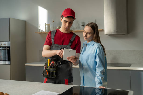 istock Professional Technician Consults Homeowner In Kitchen During Maintenance Visit 2151880581