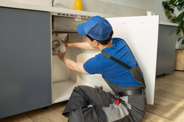 istock Professional Plumber Repairs Under-Sink Pipes in a Modern Kitchen 2151881137