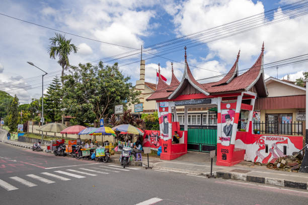 Bukittinggi, West Sumatra, Indonesia - February 5th 2024:  Official building with a colorful gate and a small street market in the front
