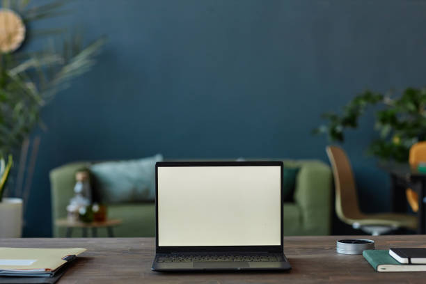 istock Open Laptop on Table in Office with Blank Screen on Teal Blue Wall 2151881220