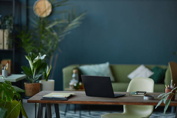 istock Office Interior with Laptop on Wooden Desk with Plants 2151881231