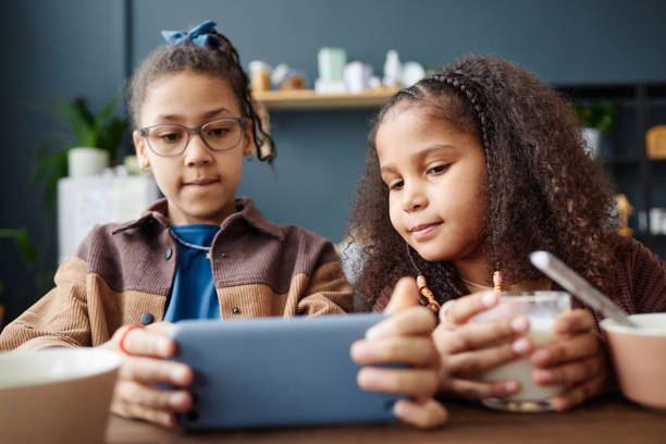 istock Two Black Girls Using Phone at Breakfast 2151882558
