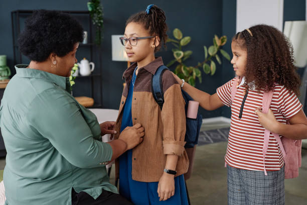 istock Black Senior Woman Helping Girl with Backpack 2151882628