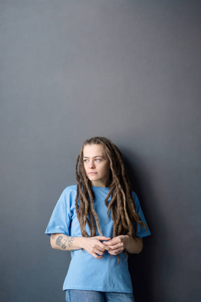 istock Woman with Dreadlocks Standing by Grey and Looking Away 2151883937
