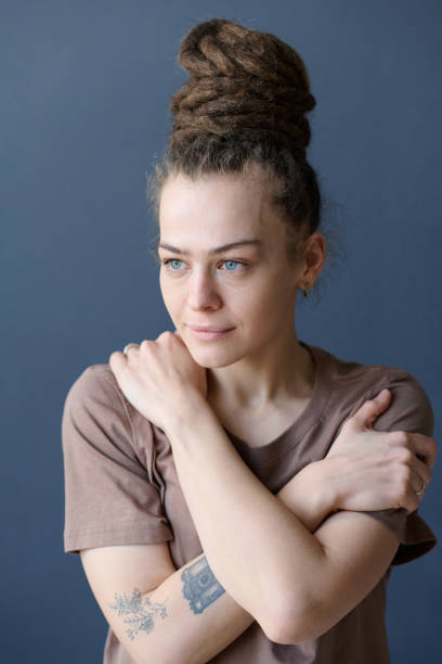 istock Smiling Woman with Dreadlocks in Bun and No Makeup Looking Away on Grey 2151883944