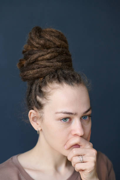 istock Close Up Woman with Dreadlocks in Bun Looking Away Concerned Face Expression 2151883955