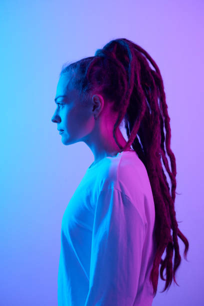 istock Side view young woman with long dreadlocks in neon light 2151883978