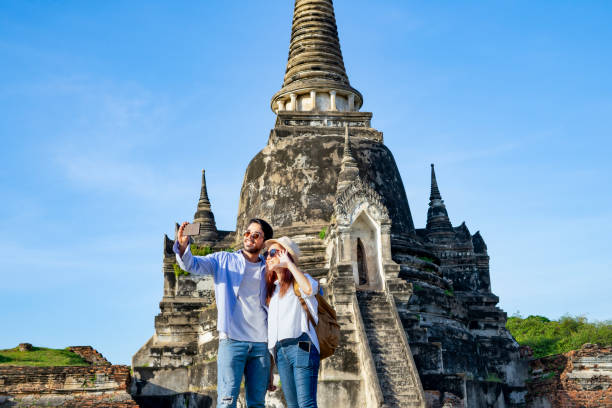 istock young couple tourist taking selfie while visiting at Wat Phra Si Sanphet, Ayutthaya historical park 2151887708