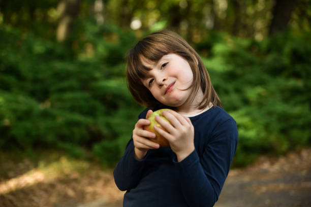 Little girl is holding yellow apple in her hand. Close-Up Healthy Eating Concept.