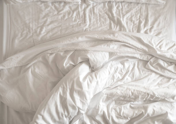 istock Morning time, messy, crumpled used white blanket on a bed, top view 2151890725