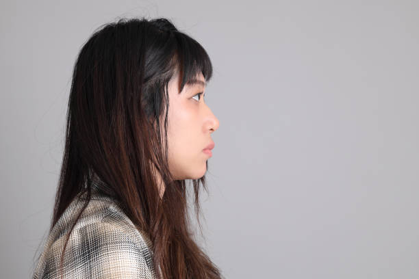 Portrait of a furious young woman with long, dark hair showing her disapproval and annoyance