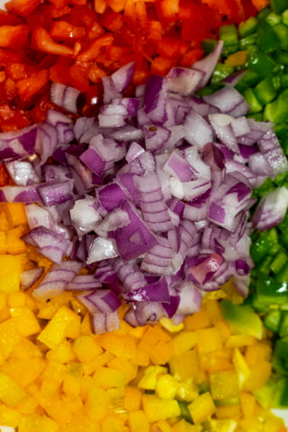 Vegetable salad. Arrangement with onion, corn, mango, tomato, green pepper and red pepper. Vertical.