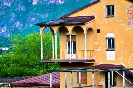 Bozen, Italy, April 14, 2024: Aging Italian villa with yellow peeling paint