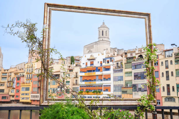 View of the Cathedral and the colorful houses of the Onyar river with flowers. Temps de Flors 2024.