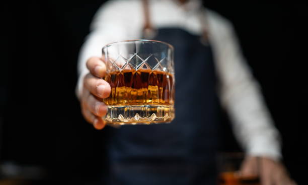 istock Barman pouring whiskey whiskey glass beautiful night 2151899236