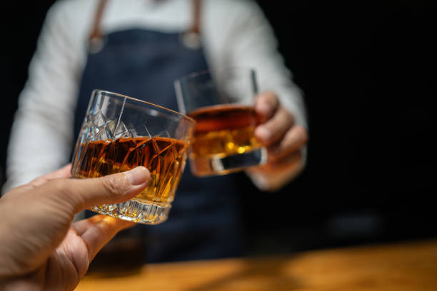 istock Barman pouring whiskey whiskey glass beautiful night 2151899238