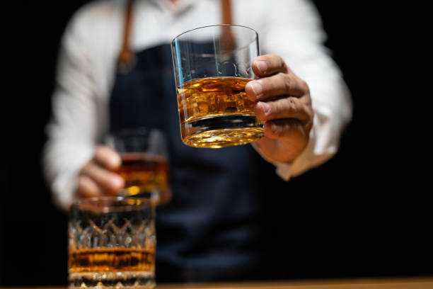 istock Barman pouring whiskey whiskey glass beautiful night 2151899239