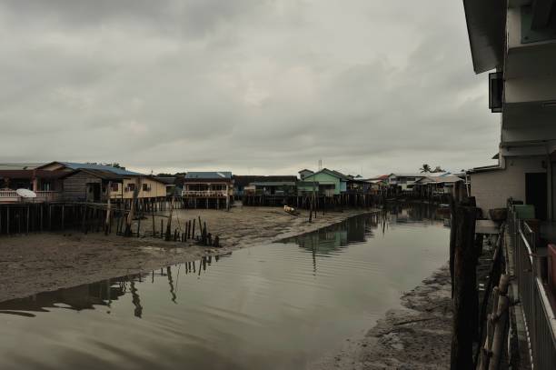 istock river reflection muddy water moored boat stilt houses cloudy sky 2151902673