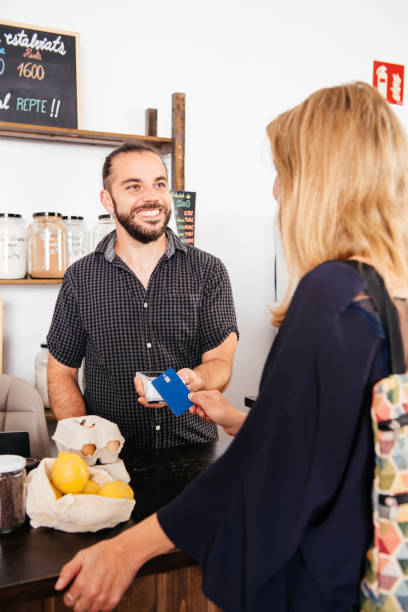 istock Smiling Customer Using Credit Card at Grocery Store Checkout During Daytime 2151903649